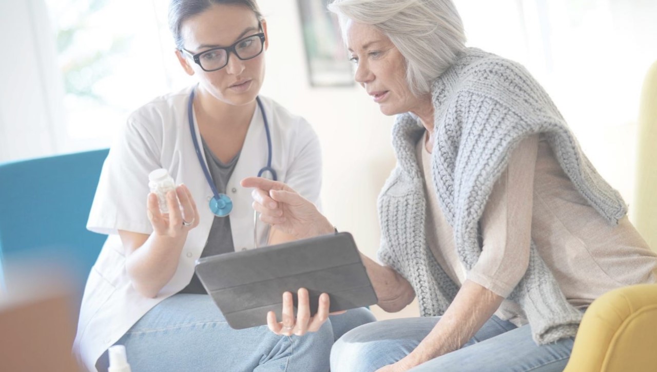 A clinician and patient reviewing care together on a tablet