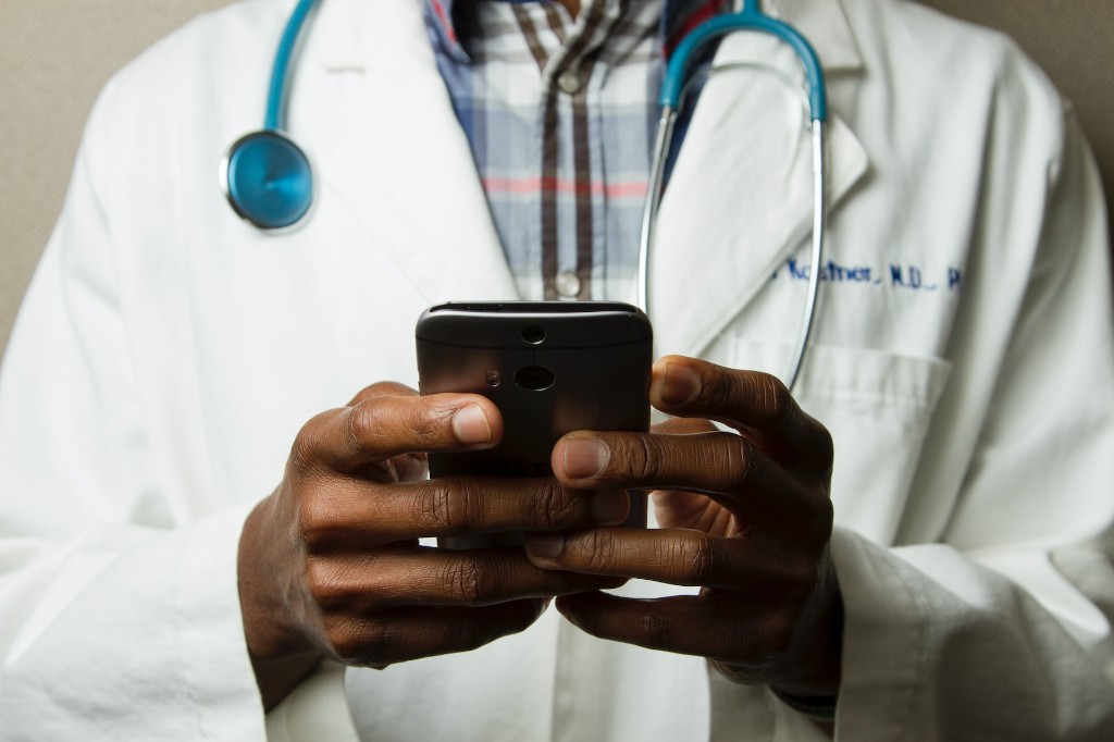 A healthcare professional using a smartphone during a telehealth consultation